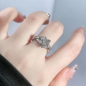 Close-up of a sparkling silver flower ring studded with stones worn on a finger