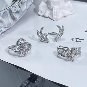 Close-up detail of antler, four-leaf clover, and flower rings with cubic zirconia crystals