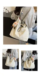Vistas multiángulo de un bolso tote de nailon blanco con cordón y dije de peluche