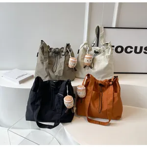 Colección de bolsos tote grandes de nailon de colores con colgantes de felpa.