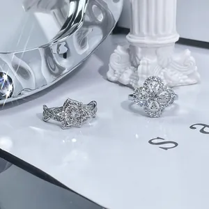 Close-up of elegant silver clover and flower rings decorated with sparkling crystals.