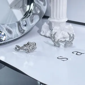 Detail shot of silver-colored rings featuring deer antler and sparkling flower designs.