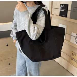 Detailansicht einer schwarzen Canvas-Einkaufstasche mit shangcallbag jingpin Stickerei.