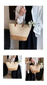 Detalle de una gran bolsa de playa de paja con asas de bambú y flores blancas