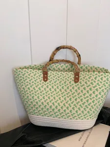 Bolso de playa grande de paja tejida con patrones verdes y blancos y asas de bambú