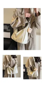 Detailed views of a large cream faux leather hobo bag with cute bear keychain accessory.