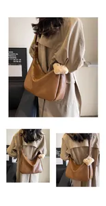 Close-up of large brown Maillard style hobo bag with teddy charm on model's shoulder