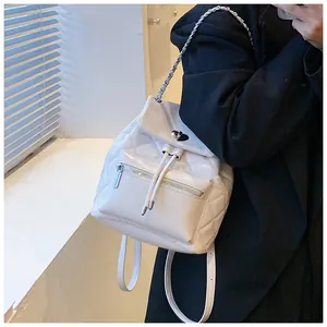 Gros plan d'un sac à dos blanc matelassé avec bretelles en chaîne et fermoir en cœur