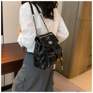 Vue d'un sac à dos en cuir noir matelassé avec fermoir coeur et bretelles en chaîne élégantes