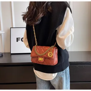 Vista posteriore di una donna con una borsa a tracolla trapuntata marrone e catena dorata