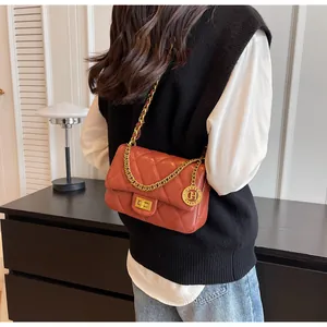 Vista dettagliata di una borsa a tracolla trapuntata rosso mattone su una modella