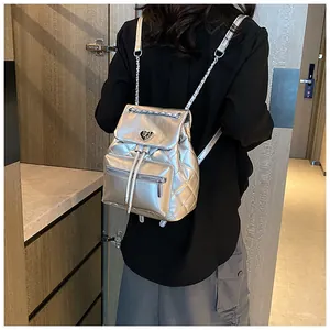 Vue arrière détaillée d'un sac à dos matelassé argenté avec des bretelles en chaîne élégantes