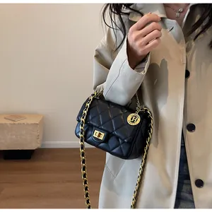 Vista dettagliata di una borsa trapuntata nera con catena abbinata a un trench beige