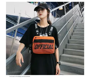 Close-up of vibrant orange tactical vest bag shown on model in urban street setting.