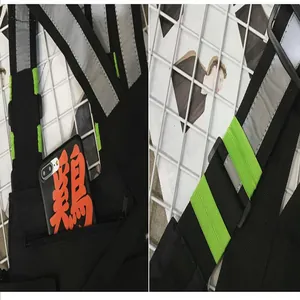 Detalle de las tiras reflectantes y el bolsillo de un bolso de pecho táctico negro