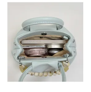 Interior view of mint green pleated cloud handbag showing large storage capacity.