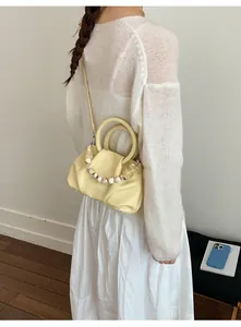 Close-up of elegant pleated cloud bag with decorative marble bead handle for women