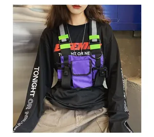 Close-up detail of a purple tactical chest bag with reflective straps worn in a street style