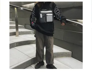 Nahaufnahme einer reflektierenden schwarzen taktischen Brusttasche im Techwear-Stil für Urban.