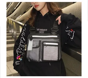 Nahaufnahme einer silbernen reflektierenden Techwear-Brusttasche an einem Modell