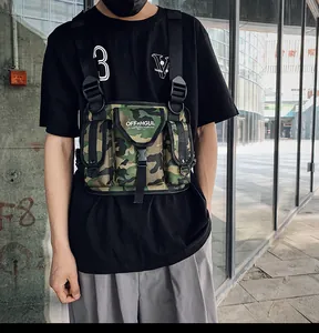 Detalle de un bolso de pecho táctico de camuflaje unisex sobre una camiseta negra techwear.