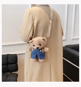 Back view of a person wearing a cute brown plush teddy bear crossbody bag with denim overalls