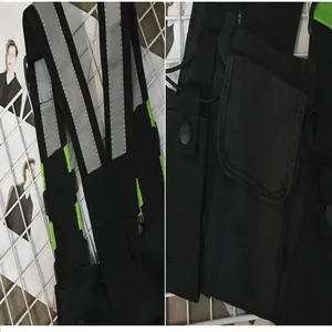 Detailed view of a black tactical chest bag with reflective straps and green accents