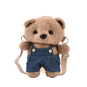 Cute plush teddy bear crossbody bag featuring denim overalls and tan shoulder strap
