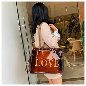 Bolso tote transparente de PVC marrón con letras LOVE llevado por una modelo