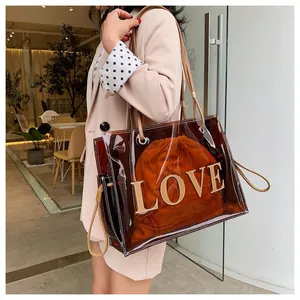 Primer plano de un elegante bolso tote de PVC marrón transparente con estampado 'LOVE' y sobre.