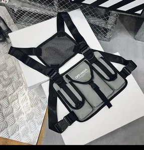 Detalle del bolso táctico gris techwear con correas ajustables y bolsillos frontales