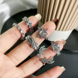 Close-up of sparkling heart and antler shaped silver rings with clear stone accents.