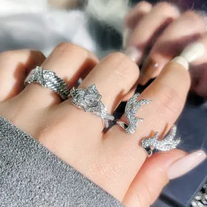 Close-up of sparkling silver rings with antler and heart designs on a hand