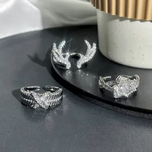 Close-up of three sparkling silver adjustable rings with antler, cross, and flower designs