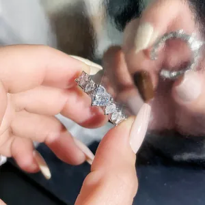 Close-up of elegant silver ring featuring heart-shaped and mixed-cut sparkling stones.