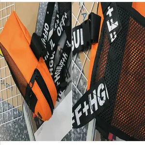 Detailed view of orange and black tactical chest bag with mesh and printed straps.