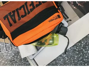 Close-up detail of orange tactical chest rig bag with black mesh and streetwear logo
