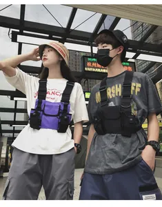 Male and female models wearing purple and black tactical chest rigs for techwear style