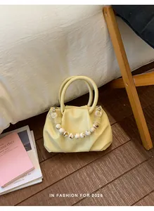 Detailed view of light yellow pleated cloud bag with marble-effect beaded handle