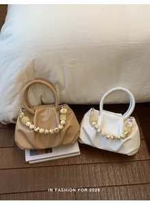 Two stylish pleated cloud handbags in khaki and white with decorative bead handles