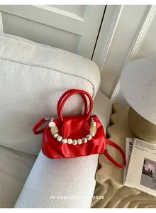 Fashionable red gathered cloud handbag featuring a chunky decorative marble bead chain