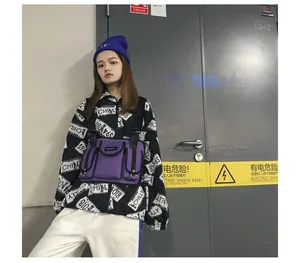 Detail der violetten taktischen Brusttasche, getragen über einer Grafikjacke im Streetstyle.