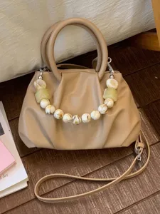 Elegant beige ruched cloud handbag featuring a unique marbleized bead handle for women
