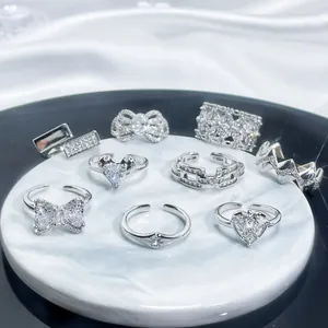 Set of silver-colored open rings with sparkling cubic zirconia on a marble tray