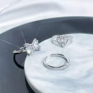 Macro detail view of three silver adjustable rings featuring heart and bow crystal designs.