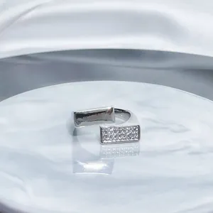 Macro shot of a minimalist silver-tone open ring featuring geometric pavé crystals