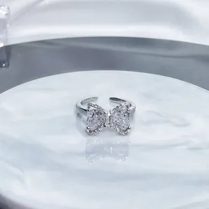 Macro view of sparkling crystal paved bow-knot open ring in elegant silver finish