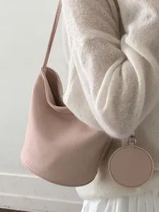 Elegant minimalist large capacity bucket bag in soft pink with a matching circular coin purse