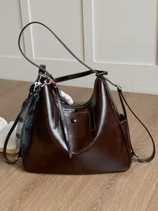 Grande borsa tote marrone in ecopelle con dettaglio sciarpa in ambiente luminoso