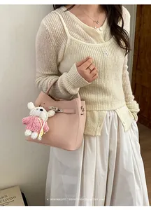 Detailansicht der eleganten rosa Leder-Eimertasche mit süßem Plüschbären-Anhänger